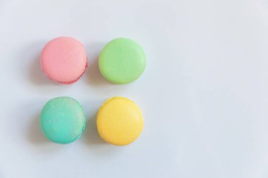 Tatlı badem renkli pembe, mavi, sarı, yeşil macarons beyaz arka plan üzerinde