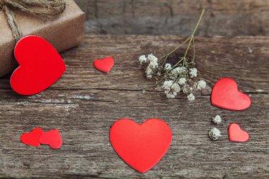 Hediye kutusu mevcut kaydırılan Kraft kağıt rustik trendy eski vintage ahşap zemin üzerine kırmızı kalp. 