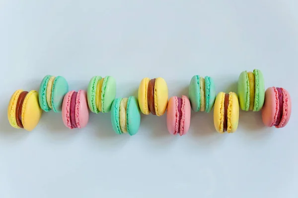 Sweet almond colorful pink, biue, yellow, green macaron or macaroon dessert cake isolated on white background. French sweet cookie. Minimal food bakery concept. Flat lay, top view, copy space