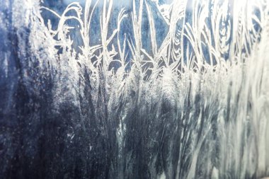 Donmuş kış penceresi, parlak buz desenli. Noel mucizesi sembolü, soyut arka plan. Kuzey sıcaklığı aşırı düşük, buz gibi camlarda doğal kar, açık havada serin kış havası