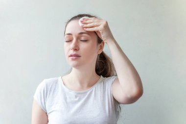 Güzellik makyaj ile beyaz arka plan üzerinde izole pamuk yastık çıkarmadan yumuşak sağlıklı cilt ile gülümseyen bir esmer kadın portresi. Cilt Bakımı temizlik spa kavramı relax