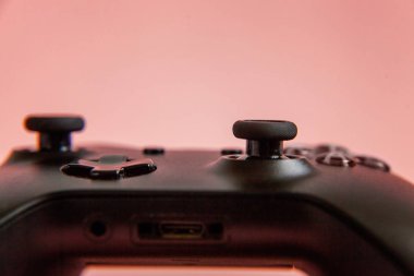 Siyah joystick gamepad, pembe renkli şık modern moda pin-up arka plan üzerinde oyun konsolu. Bilgisayar oyun yarışması video oyunu denetim çatışma kavramı. Siber sembolü