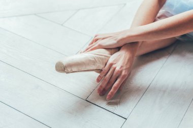 Balerin mavi tutu etekle elinde pointe ayakkabı bacak beyaz ışık salonunda koyar. Genç Klasik Bale dansçısı kadın dans sınıf