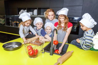 Mutlu aile mutfak. Anne ve beş çocuk hamur, fırında elmalı turta hazırlanıyor. Anne, kızı ve oğlu evde sağlıklı yemek pişirme ve eğleniyor. Yardım, ev içi, ekip çalışması annelik kavramı