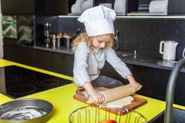 Chef şapka, oklavayla hamuru hazırlama ile küçük kız ev yapımı tatil elmalı turta mutfak pişirin. Evde sağlıklı yemek pişirme ve having fun evlat. Çocukluk, ev içi, ekip çalışması yardımcı kavramı