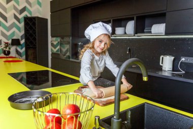 Chef şapka, oklavayla hamuru hazırlama ile küçük kız ev yapımı tatil elmalı turta mutfak pişirin. Evde sağlıklı yemek pişirme ve having fun evlat. Çocukluk, ev içi, ekip çalışması yardımcı kavramı