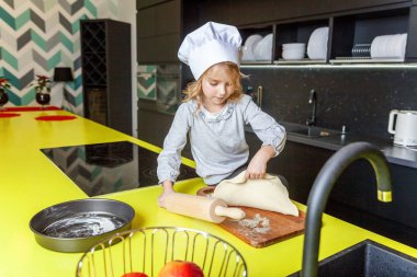Chef şapka, oklavayla hamuru hazırlama ile küçük kız ev yapımı tatil elmalı turta mutfak pişirin. Evde sağlıklı yemek pişirme ve having fun evlat. Çocukluk, ev içi, ekip çalışması yardımcı kavramı