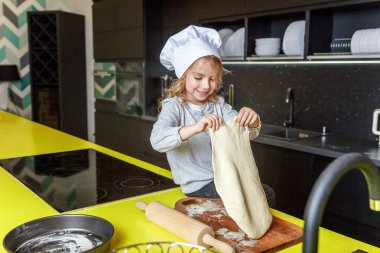 Chef şapka, oklavayla hamuru hazırlama ile küçük kız ev yapımı tatil elmalı turta mutfak pişirin. Evde sağlıklı yemek pişirme ve having fun evlat. Çocukluk, ev içi, ekip çalışması yardımcı kavramı