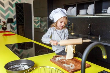 Chef şapka, oklavayla hamuru hazırlama ile küçük kız ev yapımı tatil elmalı turta mutfak pişirin. Evde sağlıklı yemek pişirme ve having fun evlat. Çocukluk, ev içi, ekip çalışması yardımcı kavramı