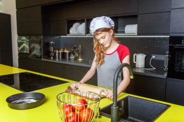 Chef şapka, oklavayla hamuru hazırlama ile genç kız ev yapımı tatil elmalı turta mutfak pişirin. Genç kadın evde sağlıklı yemek pişirme ve eğleniyor. Gıda, sağlıklı beslenme, ev kavramı