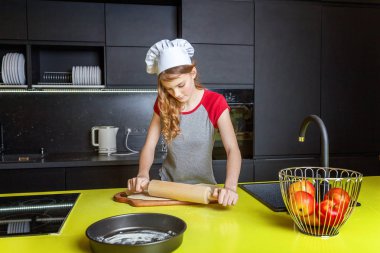 Chef şapka, oklavayla hamuru hazırlama ile genç kız ev yapımı tatil elmalı turta mutfak pişirin. Genç kadın evde sağlıklı yemek pişirme ve eğleniyor. Gıda, sağlıklı beslenme, ev kavramı
