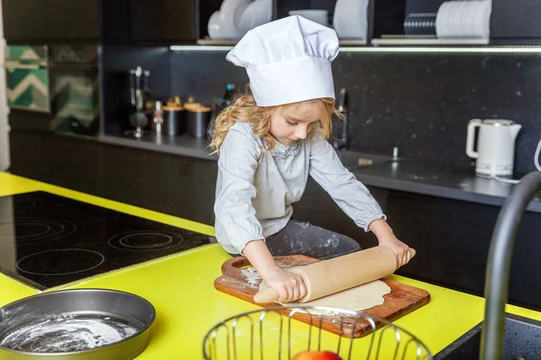 Chef şapka, oklavayla hamuru hazırlama ile küçük kız ev yapımı tatil elmalı turta mutfak pişirin. Evde sağlıklı yemek pişirme ve having fun evlat. Çocukluk, ev içi, ekip çalışması yardımcı kavramı