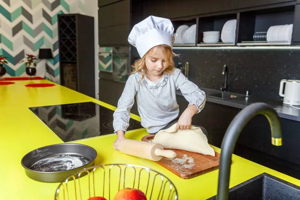 Chef şapka, oklavayla hamuru hazırlama ile küçük kız ev yapımı tatil elmalı turta mutfak pişirin. Evde sağlıklı yemek pişirme ve having fun evlat. Çocukluk, ev içi, ekip çalışması yardımcı kavramı