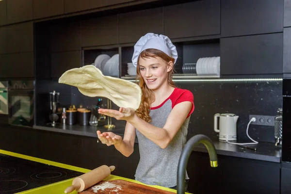 Chef şapka, oklavayla hamuru hazırlama ile genç kız ev yapımı tatil elmalı turta mutfak pişirin. Genç kadın evde sağlıklı yemek pişirme ve eğleniyor. Gıda, sağlıklı beslenme, ev kavramı