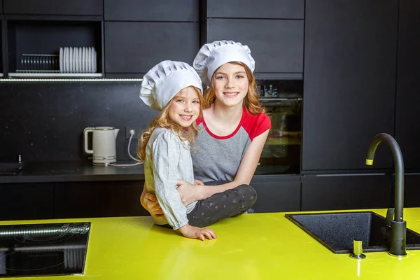Dwie Dziewczyny Szefa Kuchni Kapelusz Przytulanie Zabawy Kuchni Siostry Mały — Zdjęcie stockowe