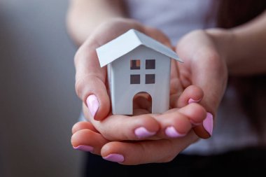 Erkek küçük minyatür beyaz oyuncak ev tutan eller. Mortgage Emlak sigorta rüya ev ve gayrimenkul konsept taşıma