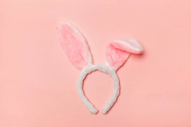 Mutlu Paskalya kavramı. Tatil için hazırlık. Dekoratif tavşan kulakları kürklü kabarık kostüm oyuncak trendy pastel pembe arka plan üzerinde izole. Üstten görünüm kopya alanı basit minimalizm düz yatıyordu