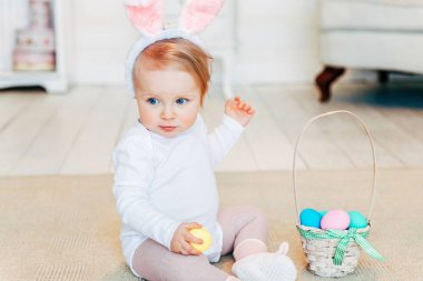 Tavşan kulakları Paskalya gününde giyen ve boyalı yumurta ile oynarken küçük çocuk kız