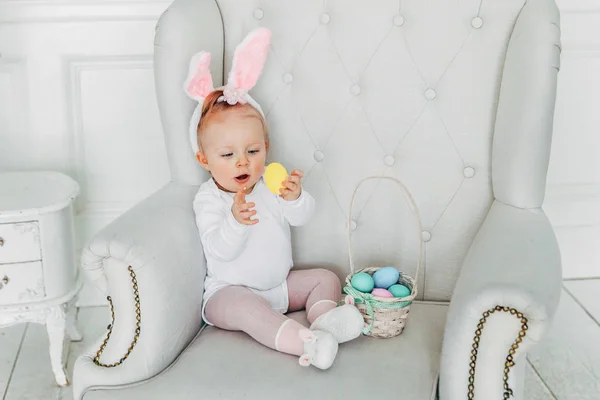 Mała dziewczynka dziecko sobie uszy królika na Wielkanoc i grając z pisanki — Zdjęcie stockowe