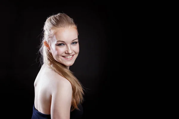 Beautiful girl with ponytail hairstyle smiling on black background — Stock Photo, Image