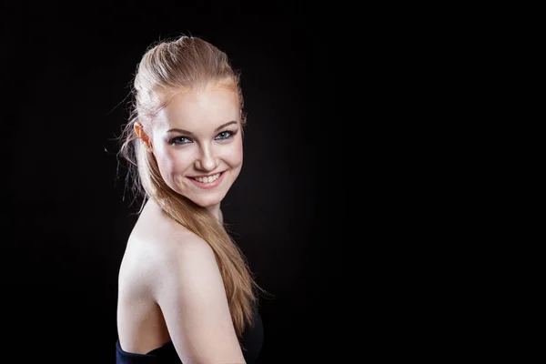 Beautiful girl with ponytail hairstyle smiling on black background — Stock Photo, Image