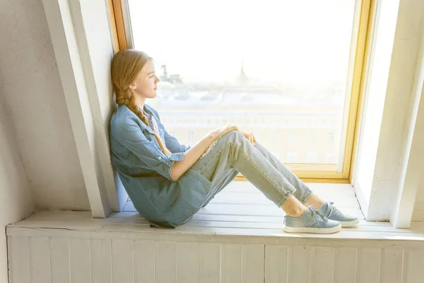 Meisje zit op een venster — Stockfoto