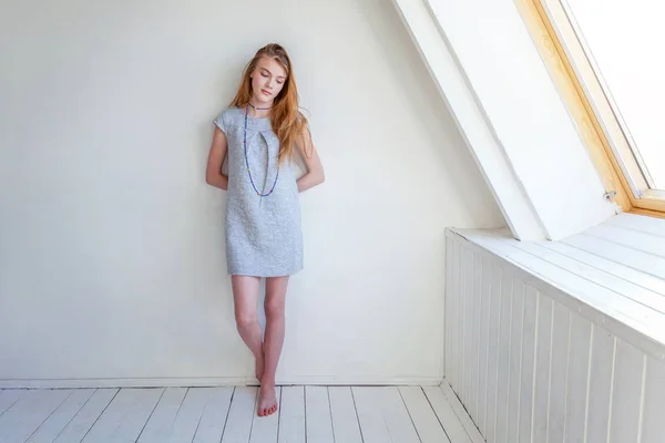 Chica en una habitación luminosa contra la pared blanca — Foto de Stock