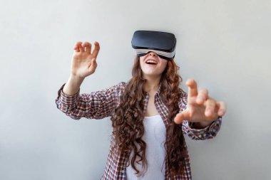 Beyaz arka planda sanal gerçeklik gözlüğü başlığı takan genç kadın gülümse. Sanal gerçeklik gözlüğü takan akıllı telefon. Teknoloji, simülasyon, yüksek teknoloji, video oyunu konsepti