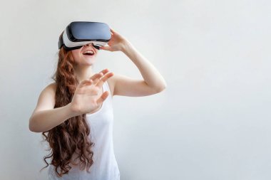 Beyaz arka planda sanal gerçeklik gözlüğü başlığı takan genç kadın gülümse. Sanal gerçeklik gözlüğü takan akıllı telefon. Teknoloji, simülasyon, yüksek teknoloji, video oyunu konsepti