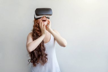 Beyaz arka planda sanal gerçeklik gözlüğü başlığı takan genç kadın gülümse. Sanal gerçeklik gözlüğü takan akıllı telefon. Teknoloji, simülasyon, yüksek teknoloji, video oyunu konsepti