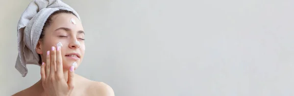 美容栄養マスクまたは分離された顔 白い背景の上のクリーム ホワイトと頭の上のタオルの女性の肖像画 スキンケア クレンジング エコ有機化粧品スパ リラックス コンセプト バナー — ストック写真