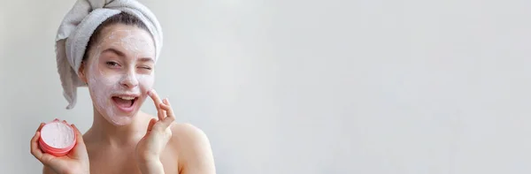 美容栄養マスクまたは分離された顔 白い背景の上のクリーム ホワイトと頭の上のタオルの女性の肖像画 スキンケア クレンジング エコ有機化粧品スパ リラックス コンセプト バナー — ストック写真