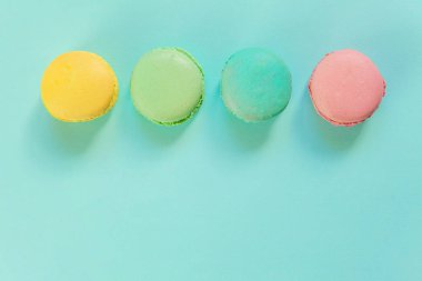 Tatlı badem rengi pembe mavi sarı badem kurabiyesi ya da modayı takip eden mavi pastada izole edilmiş badem kurabiyesi. Fransız kurabiyesi. Asgari gıda fırını konsepti. Düz görünüm kopyalama alanı