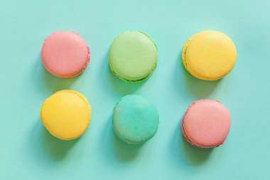 Tatlı badem rengi pembe mavi sarı badem kurabiyesi ya da modayı takip eden mavi pastada izole edilmiş badem kurabiyesi. Fransız kurabiyesi. Asgari gıda fırını konsepti. Düz görünüm kopyalama alanı