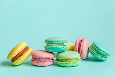 Tatlı badem rengi pembe mavi sarı badem kurabiyesi ya da modayı takip eden mavi pastada izole edilmiş badem kurabiyesi. Fransız kurabiyesi. Asgari gıda fırını konsepti. Düz görünüm kopyalama alanı