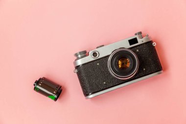 Teknoloji geliştirme hipster fotoğrafçı hobi klasik bellek gezi konsepti. Vintage film fotoğraf kamera lensi ve pembe pastel trendy modern moda pin-up arka plan üzerinde film rulo