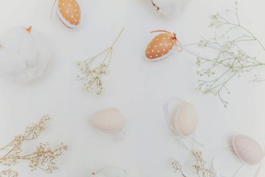 Paskalya yumurta, pamuk ve rustik Beyaz ahşap zemin üzerinde beyaz çiçeklerle dekorasyon. Paskalya kavramı. Düz yatıyordu üstten görünüm kopya alanı. Bahar tebrik kartı