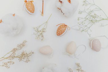 Paskalya yumurta, pamuk ve rustik Beyaz ahşap zemin üzerinde beyaz çiçeklerle dekorasyon. Paskalya kavramı. Düz yatıyordu üstten görünüm kopya alanı. Bahar tebrik kartı