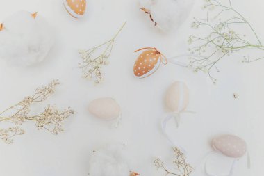 Paskalya yumurta, pamuk ve rustik Beyaz ahşap zemin üzerinde beyaz çiçeklerle dekorasyon. Paskalya kavramı. Düz yatıyordu üstten görünüm kopya alanı. Bahar tebrik kartı