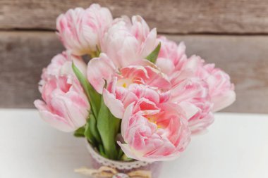 Bahar tebrik kartı. Buket taze hafif pastel pembe Lale çiçek ahşap arka plan üzerinde. Mutlu Paskalya anne gün yıldönümü Sevgililer günü doğum günü kavramı. Düz yatıyordu üstten görünüm kopya alanı