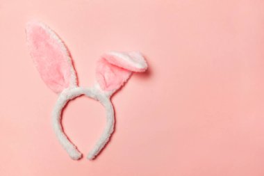 Mutlu Paskalya kavramı. Tatil için hazırlık. Dekoratif tavşan kulakları kürklü kabarık kostüm oyuncak trendy pastel pembe arka plan üzerinde izole. Üstten görünüm kopya alanı basit minimalizm düz yatıyordu
