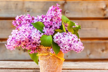 Ekoloji doğa bahar kavramı. Buket çiçek güzel rustik ahşap zemin üzerine vazo içinde mor menekşe leylak kokusu alıyorum. İlham verici doğal çiçek bahar çiçek Bahçe veya park