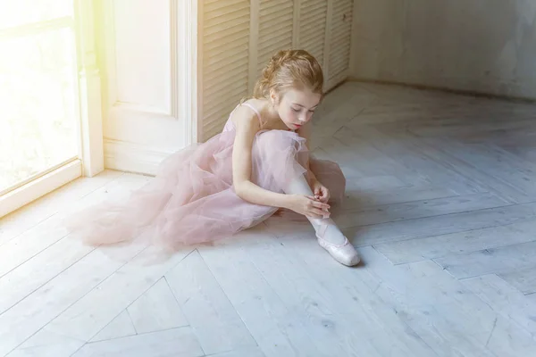 舞蹈课上年轻的古典芭蕾舞女 穿着粉红短裙的美丽优雅的芭蕾舞演员在白色灯堂的大窗边穿上尖鞋 — 图库照片