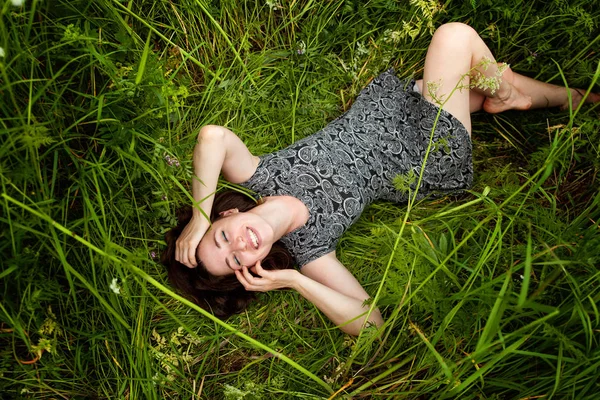 ブルネットの女性は 緑の草の上に横たわる 美少女屋外リラクゼーションと自然を楽しんでいます 無料幸せな女 トップ ビュー — ストック写真