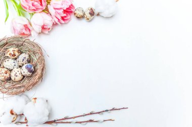 Bahar tebrik kartı. Paskalya yumurtaları içinde iç içe pamuk söğüt dalı ve pembe taze Lale çiçek buketi beyaz rustik ahşap zemin üzerinde. Paskalya kavramı. Düz yatıyordu üstten görünüm kopya alanı. Bahar çiçekler