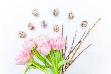 Bahar tebrik kartı. Paskalya yumurtaları söğüt dalı ve pembe taze Lale çiçek buketi beyaz rustik ahşap zemin üzerinde pamuk. Paskalya kavramı. Düz yatıyordu üstten görünüm kopya alanı. Bahar çiçekler