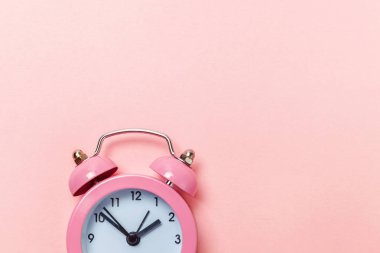 Pembe renkli pastel renkli arka planda izole edilmiş klasik alarmlı ikiz zil çalar saati. Hayatın dinlenme saatleri. İyi sabahlar. Uyanık kalma kavramı. Düz görünüm kopyalama alanı