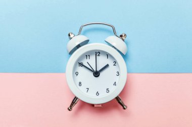 İki Yataklı çan vintage klasik çalar saat göl kenarında mavi pembe pastel renkli trendy zemin üzerine çalıyor. Yaşam süresi saat sabah gece iyi dinlen uyanık kavramı uyandır. Düz yatıyordu üstten görünüm kopya alanı