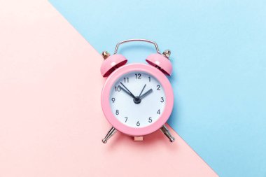 İki Yataklı çan vintage klasik çalar saat göl kenarında mavi pembe pastel renkli trendy zemin üzerine çalıyor. Yaşam süresi saat sabah gece iyi dinlen uyanık kavramı uyandır. Düz yatıyordu üstten görünüm kopya alanı