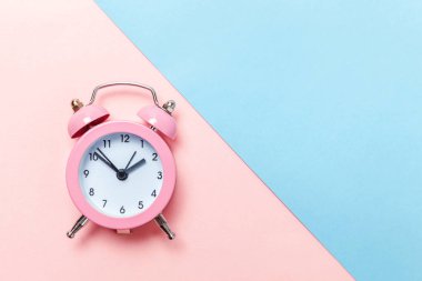 İki Yataklı çan vintage klasik çalar saat göl kenarında mavi pembe pastel renkli trendy zemin üzerine çalıyor. Yaşam süresi saat sabah gece iyi dinlen uyanık kavramı uyandır. Düz yatıyordu üstten görünüm kopya alanı